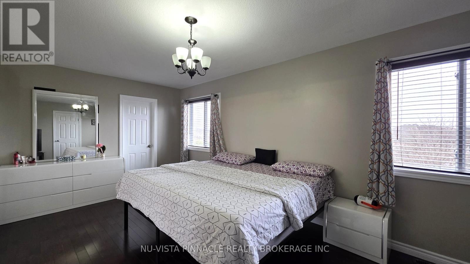 A bedroom with a large bed and a mirror on the wall.