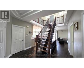 A spacious room with a staircase and a couch.