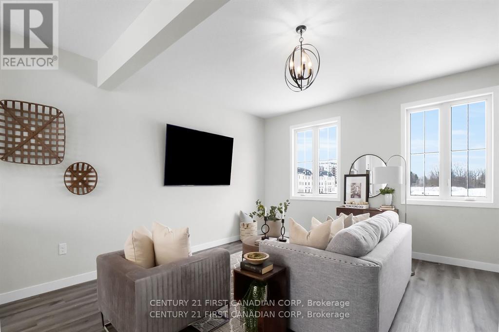 A living room with a grey couch and a flat screen TV mounted on the wall.