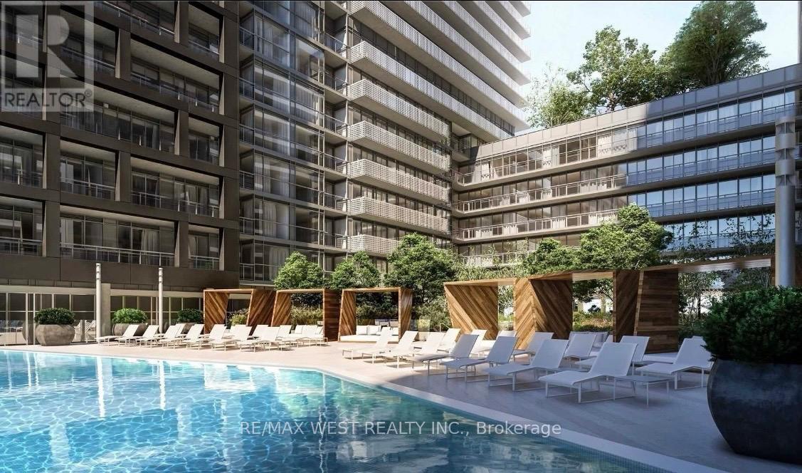 A pool area with lounge chairs and a building in the background.