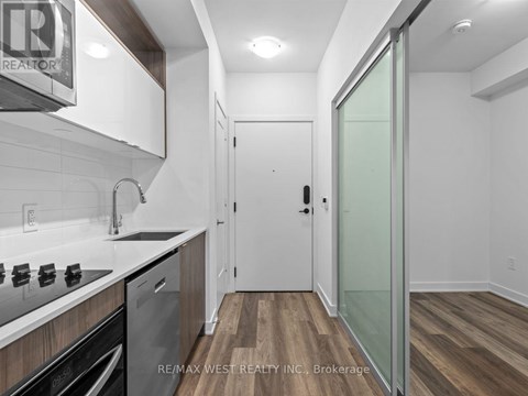 A kitchen with white cabinets and a glass door.