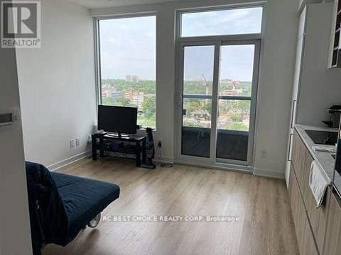 A living room with a television set on a stand and a window overlooking a cityscape.