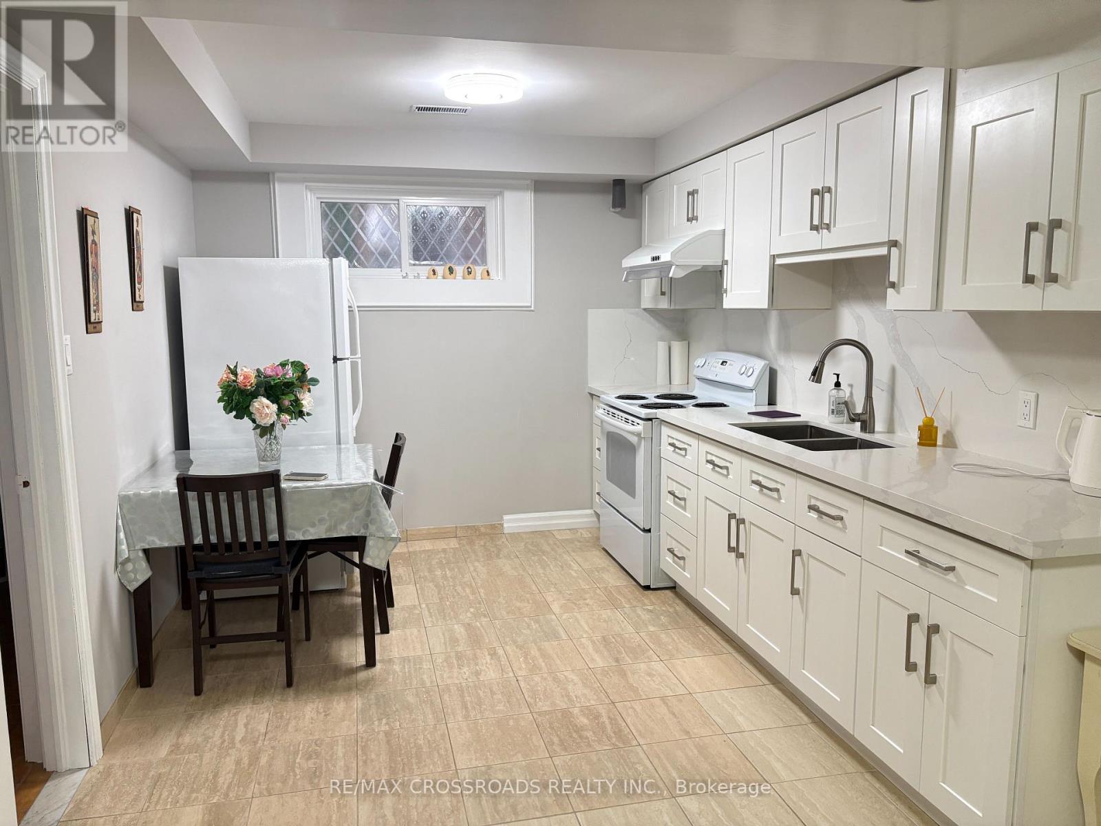 A kitchen with white cabinets and a table set for two.