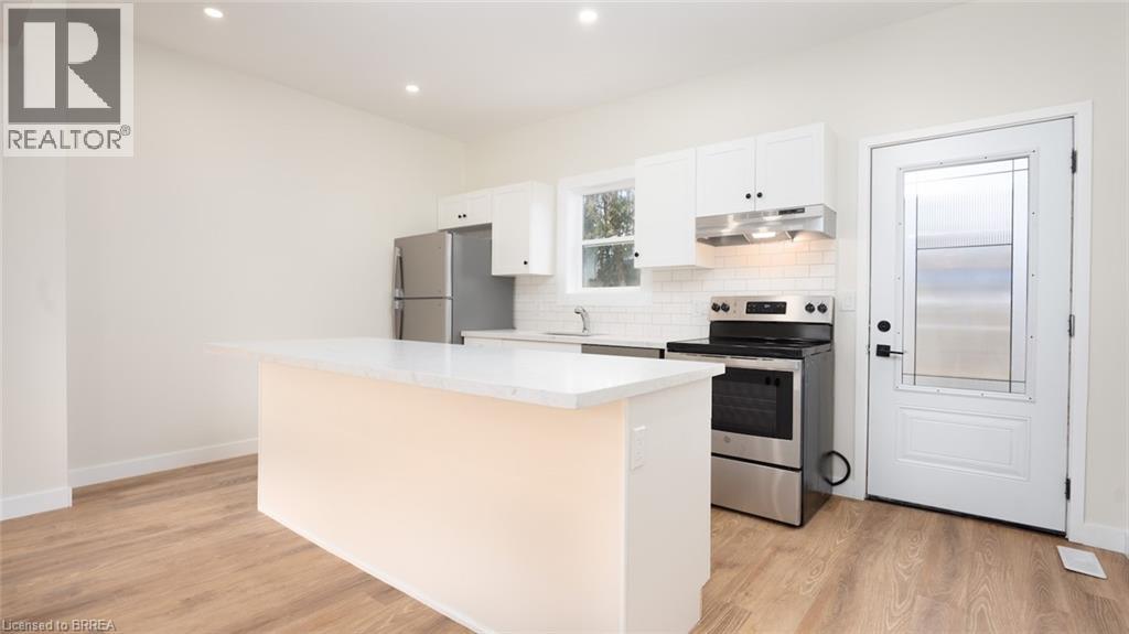 A white kitchen with a large island and stainless steel appliances.