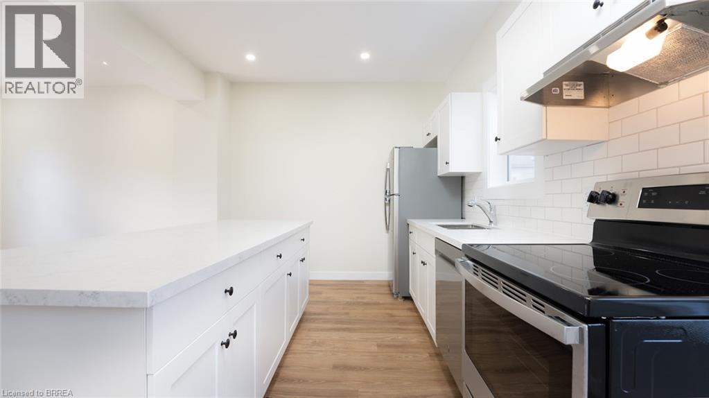 A modern kitchen with white cabinets and a black stove top.