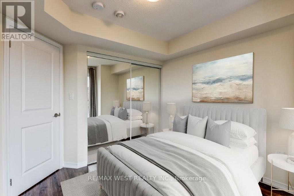 A bedroom with a large bed and a painting on the wall.