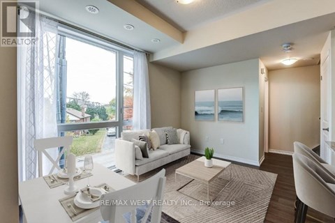 A well-lit living room with a dining table and chairs.