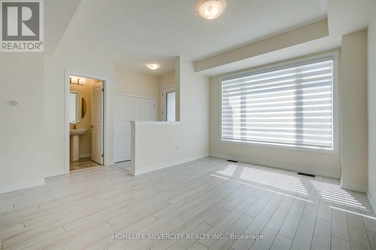A spacious room with a doorway leading to another room.