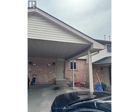 A house with a covered garage and a brick wall.