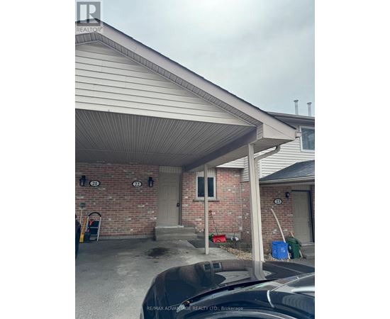 A house with a covered garage and a brick wall.