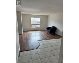 A room with a large window and a wooden floor.