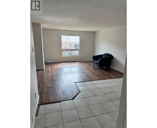 A room with a large window and a wooden floor.