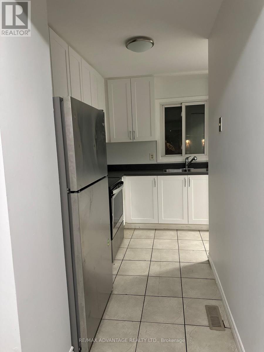 A kitchen with white cabinets and a stainless steel refrigerator.