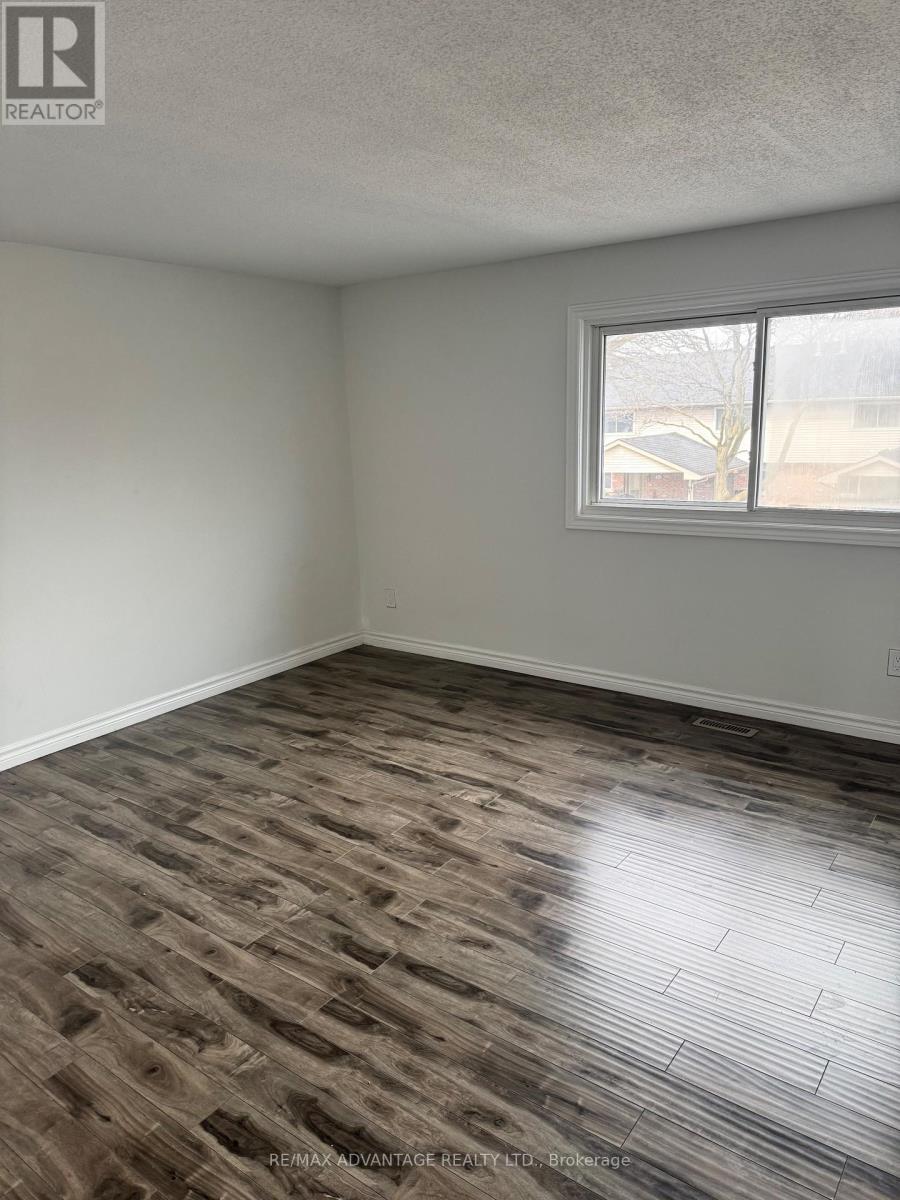 A room with a window and a wooden floor.