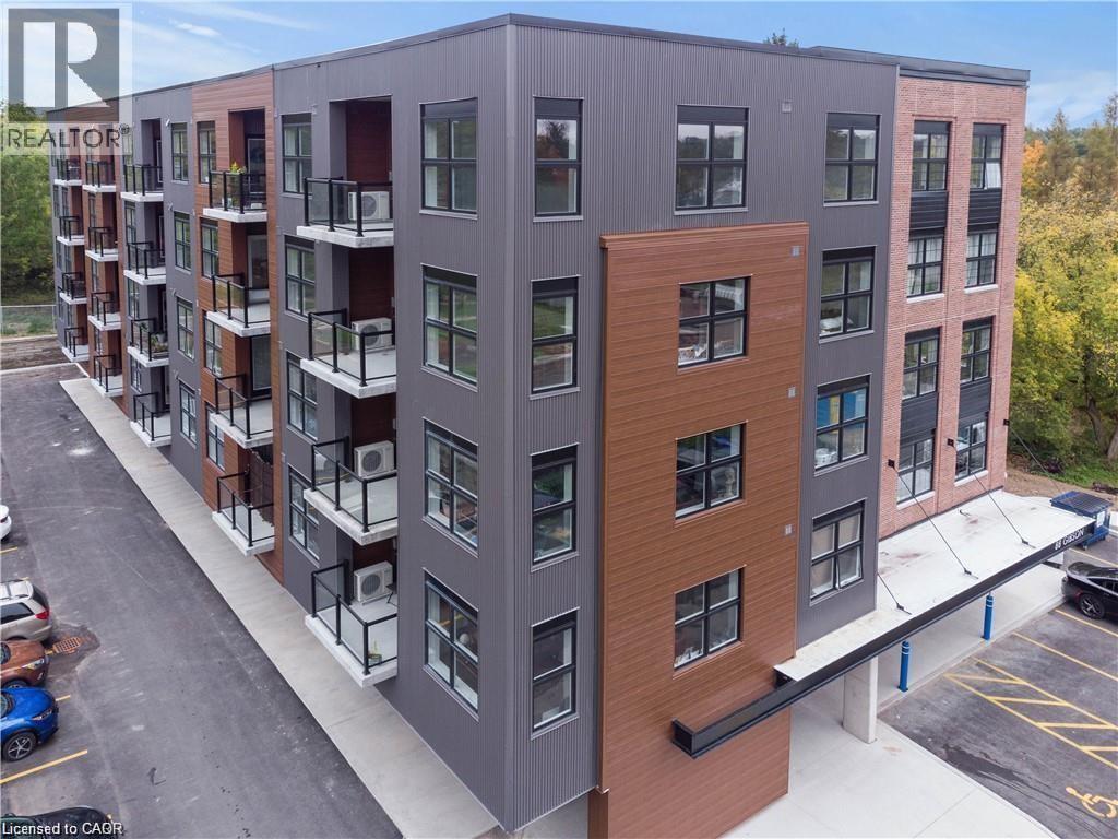 A modern apartment building with a parking lot in front.
