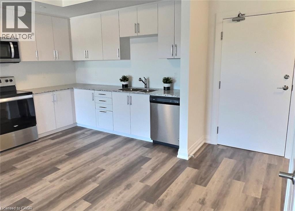 A kitchen with white cabinets and a wooden floor.