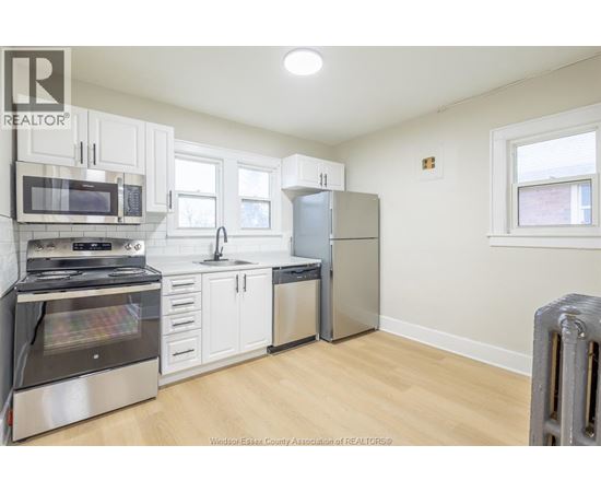 A kitchen with white cabinets and stainless steel appliances.