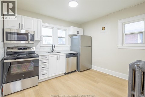 A kitchen with white cabinets and stainless steel appliances.