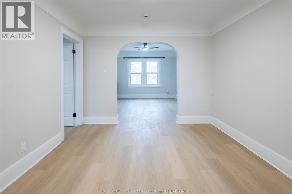 A spacious room with a wooden floor and a window.