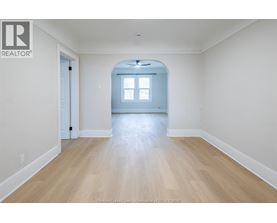 A spacious room with a wooden floor and a window.