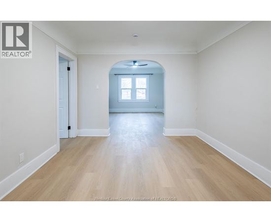 A spacious room with a wooden floor and a window.