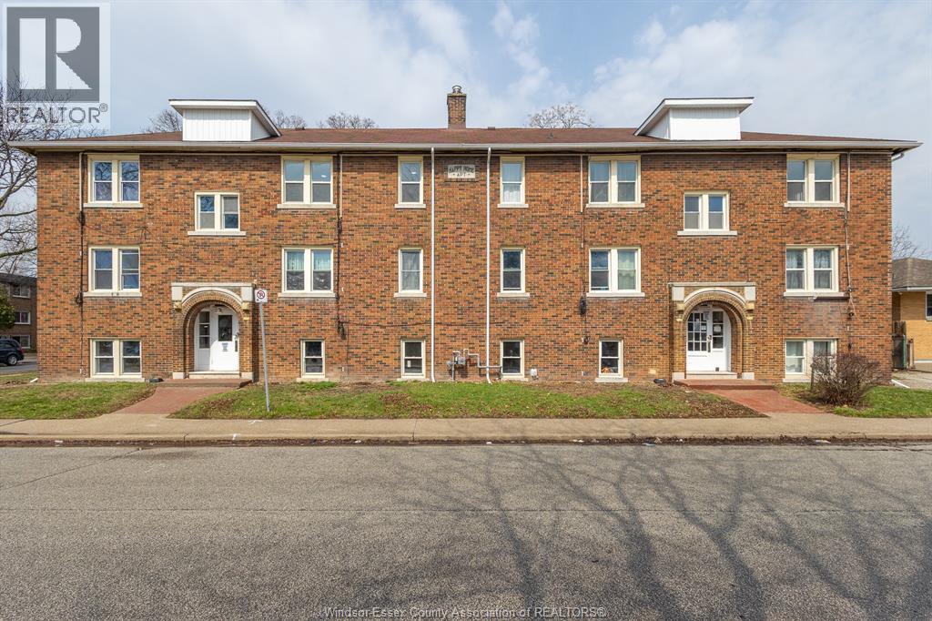 A brick building with a white door in front.