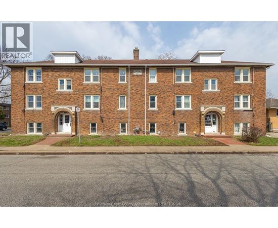 A brick building with a white door in front.