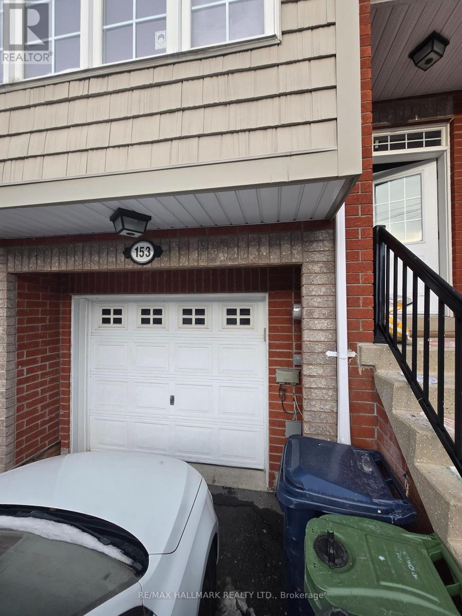 A white car is parked in front of a garage door.