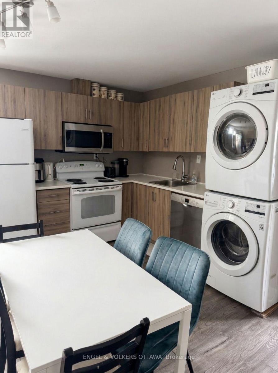 A kitchen with a washer and dryer stacked on top of each other.