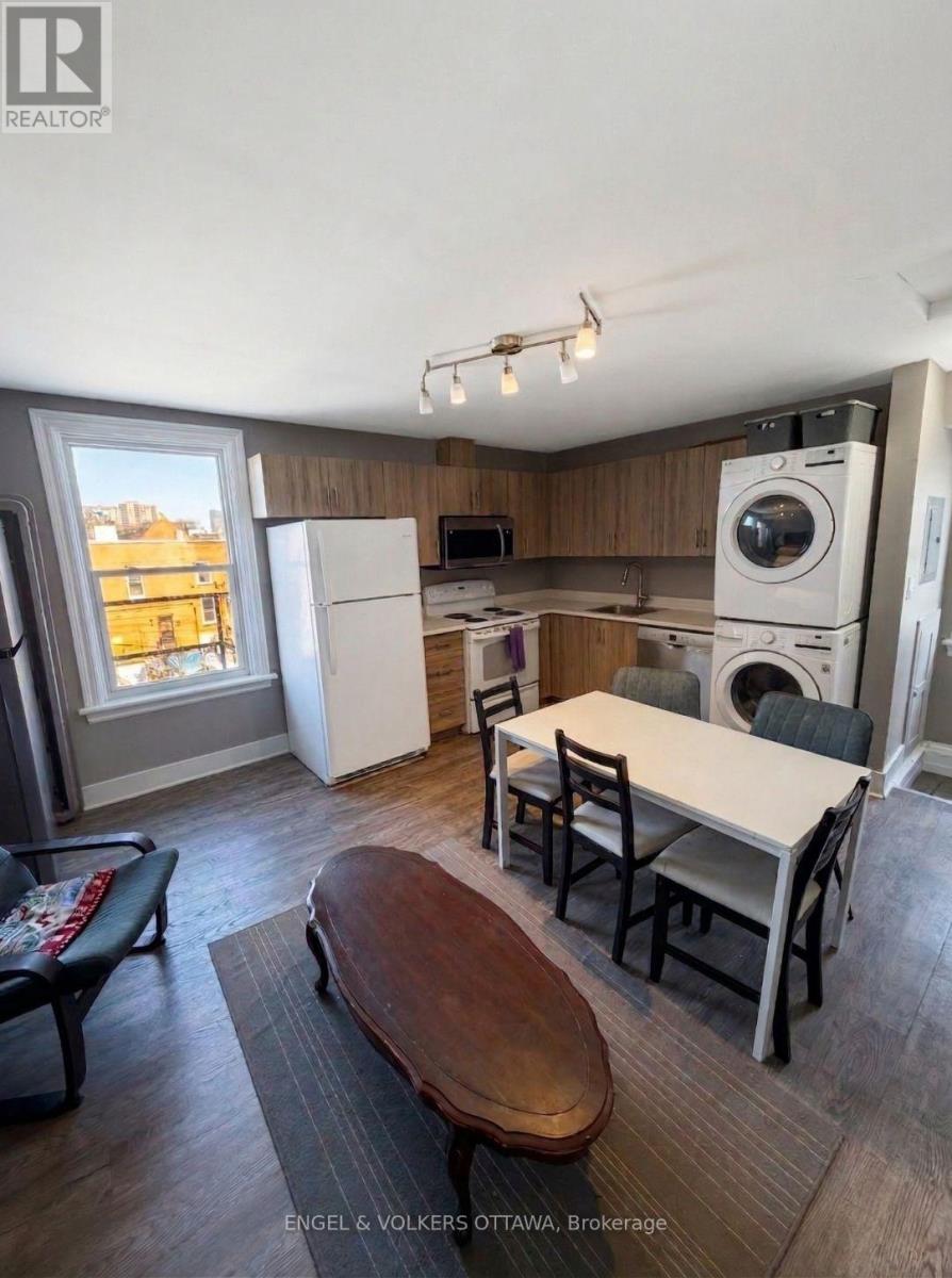 A kitchen with a table and chairs in front of a window.
