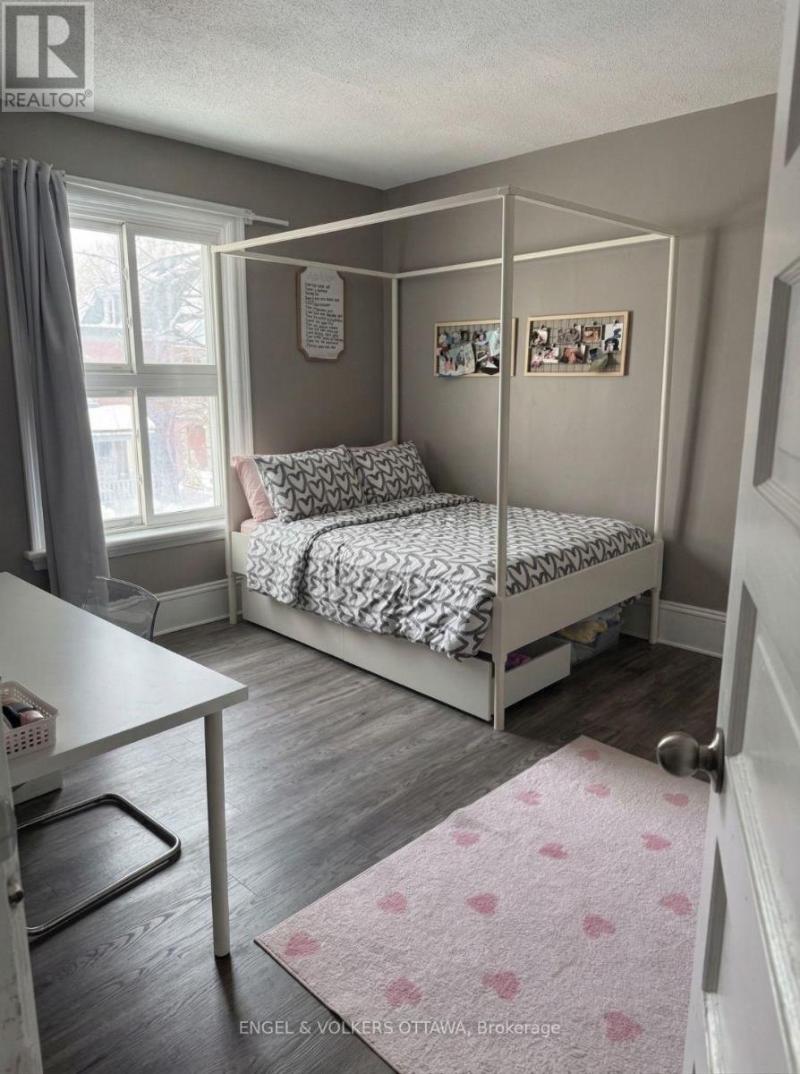 A bedroom with a four poster bed and a pink rug.
