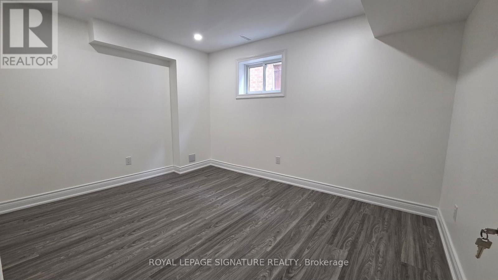 A room with a wooden floor and a window.