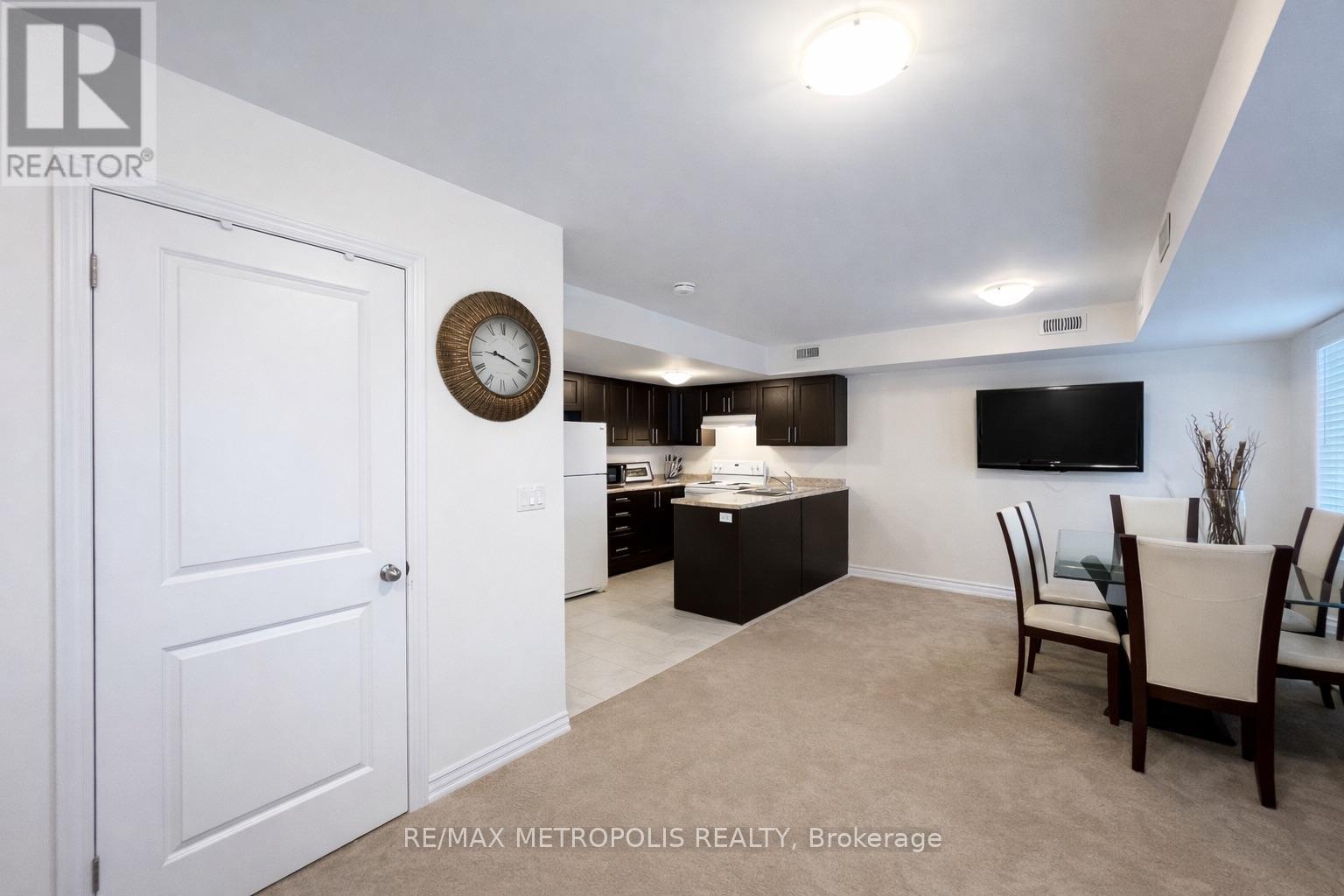 A living room with a white door and a clock on the wall.