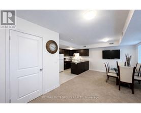 A living room with a white door and a clock on the wall.