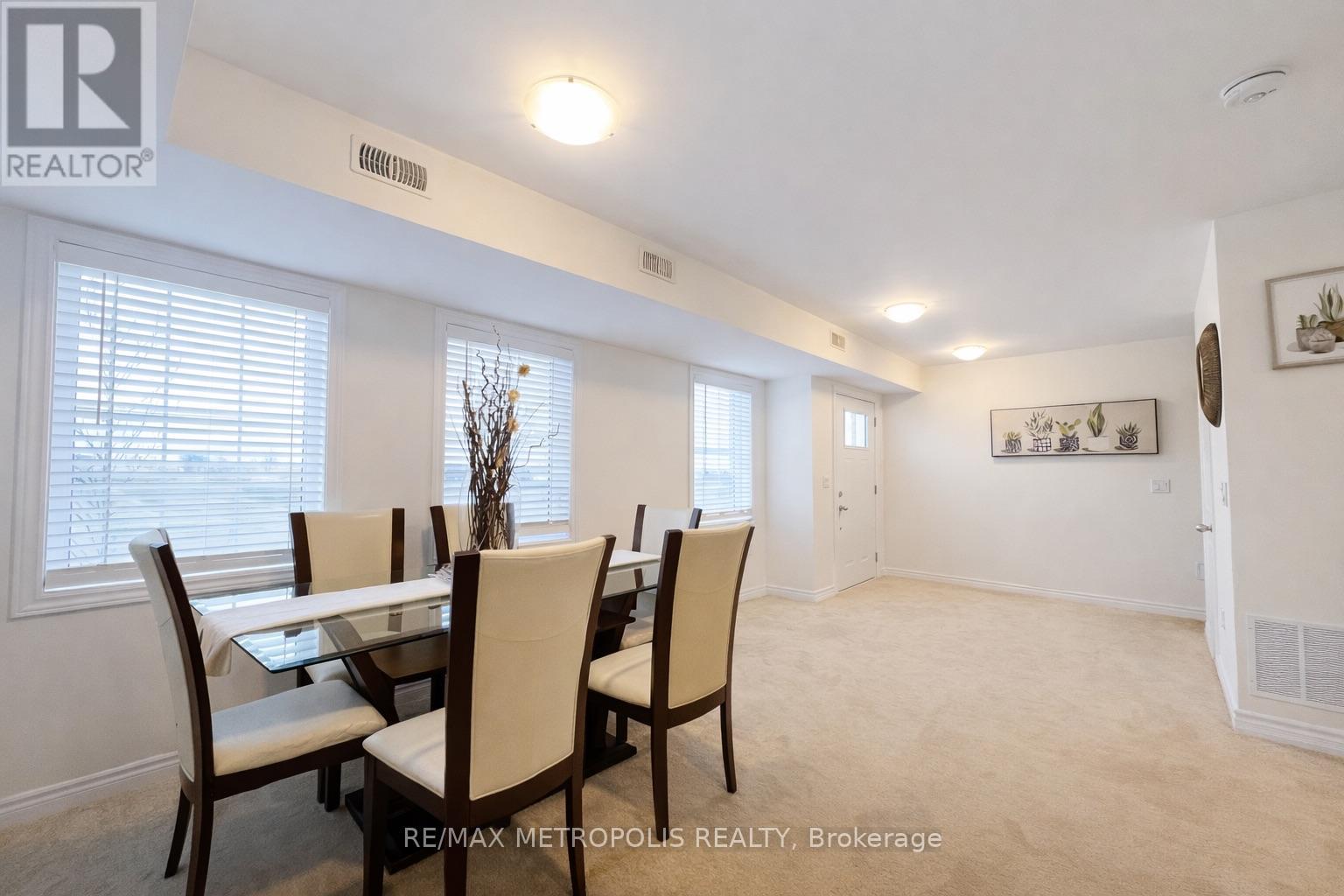 A dining room with a table and chairs.