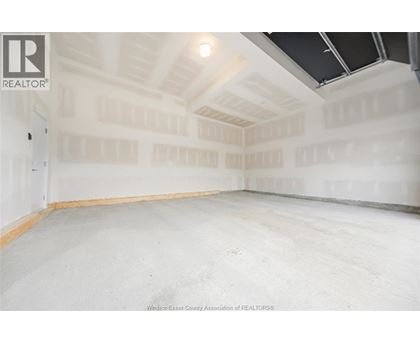 A spacious empty room with a high ceiling and skylight.