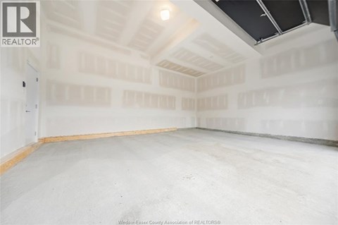 A spacious empty room with a high ceiling and skylight.