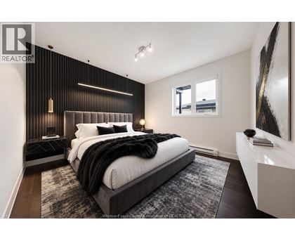 A bedroom with a large bed and a painting on the wall.