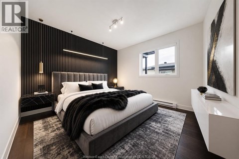 A bedroom with a large bed and a painting on the wall.