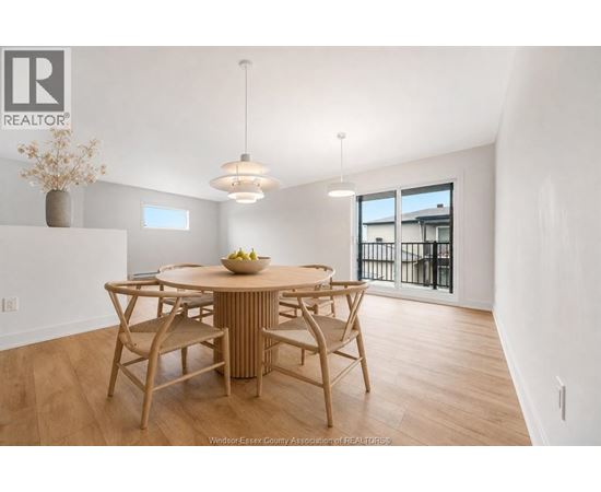 A dining room with a wooden table and chairs.