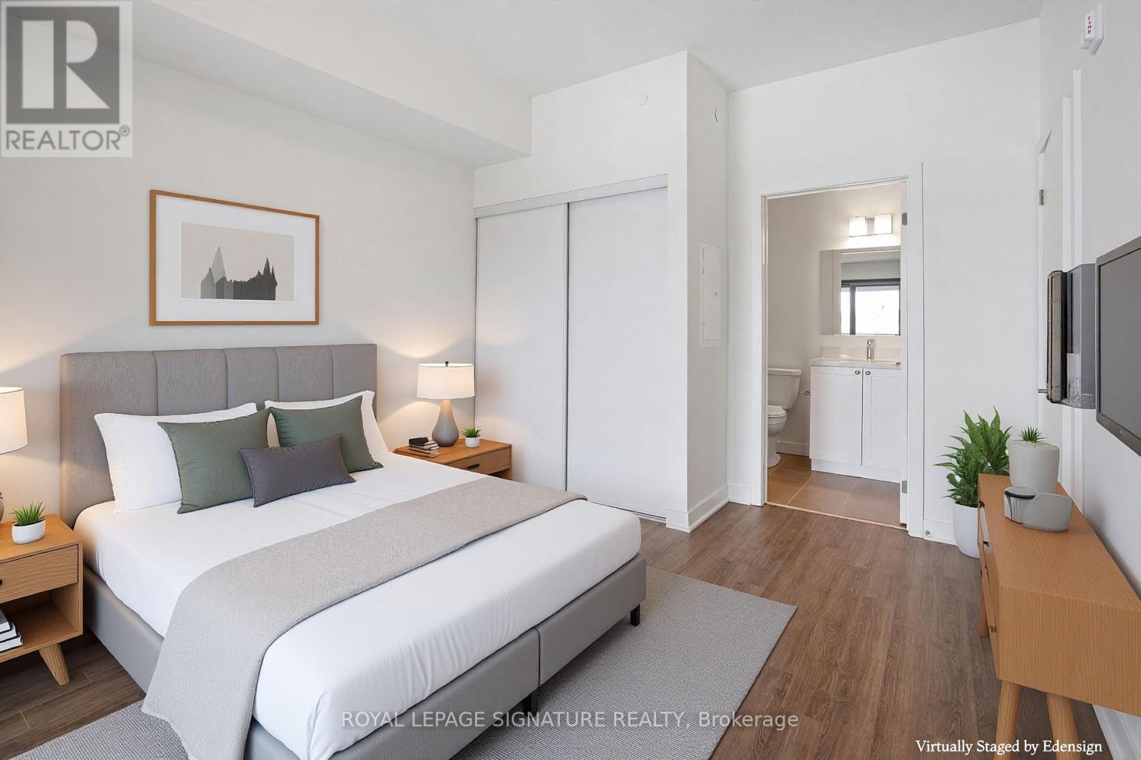 A bedroom with a large bed and a television on the wall.