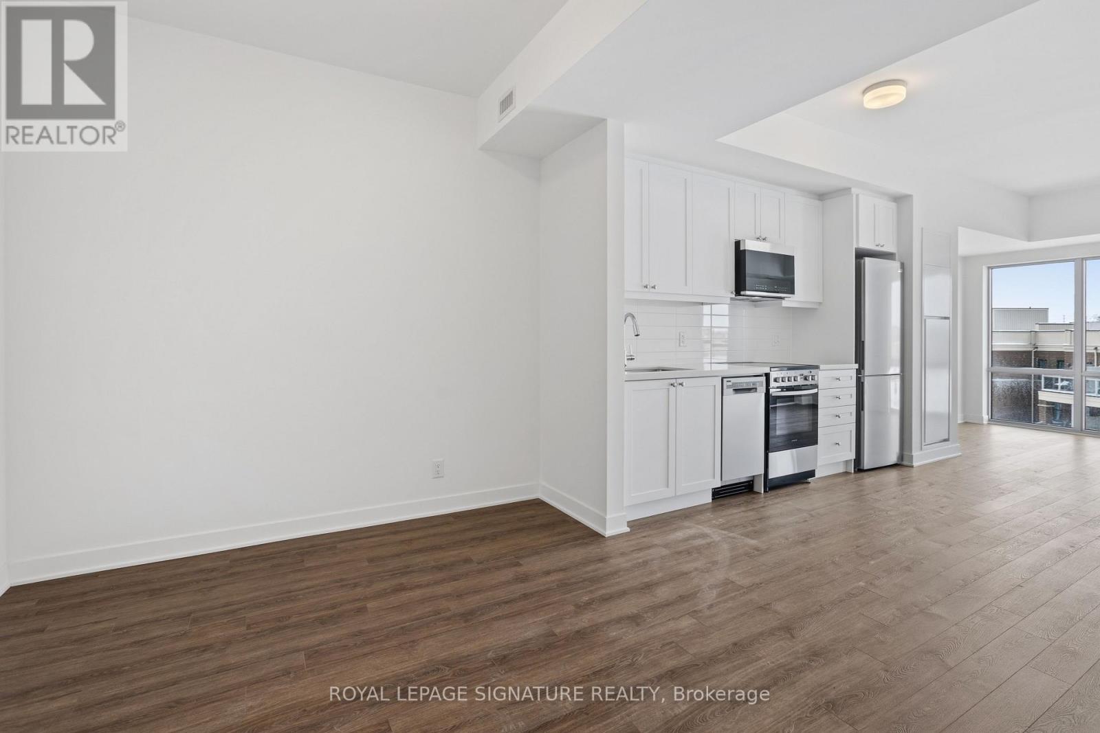 A white kitchen with a microwave and oven built into the cabinetry.