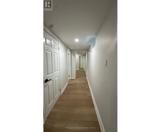 A long hallway with white doors and wooden floors.
