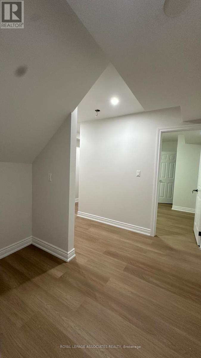 A room with wooden flooring and white walls.