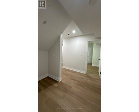 A room with wooden flooring and white walls.