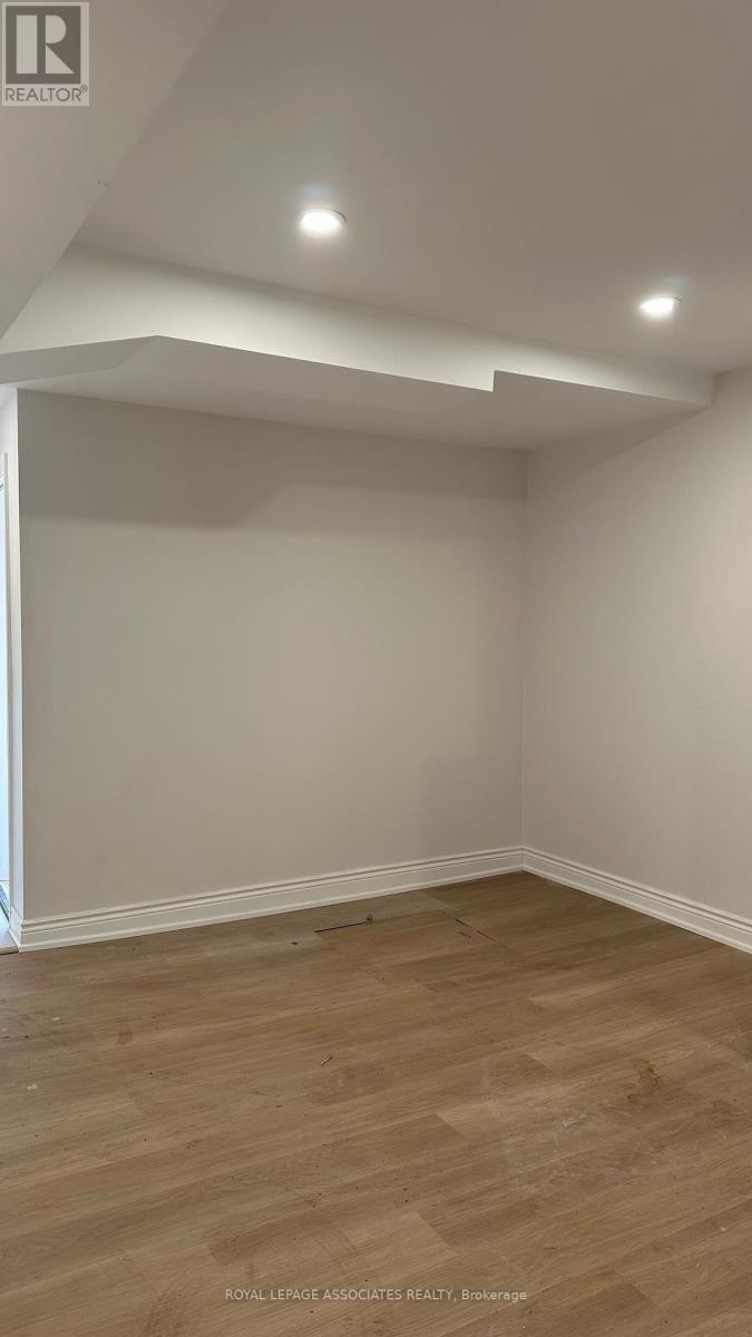 A room with wooden flooring and white walls.