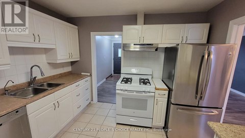 A kitchen with white cabinets and a stove top oven.