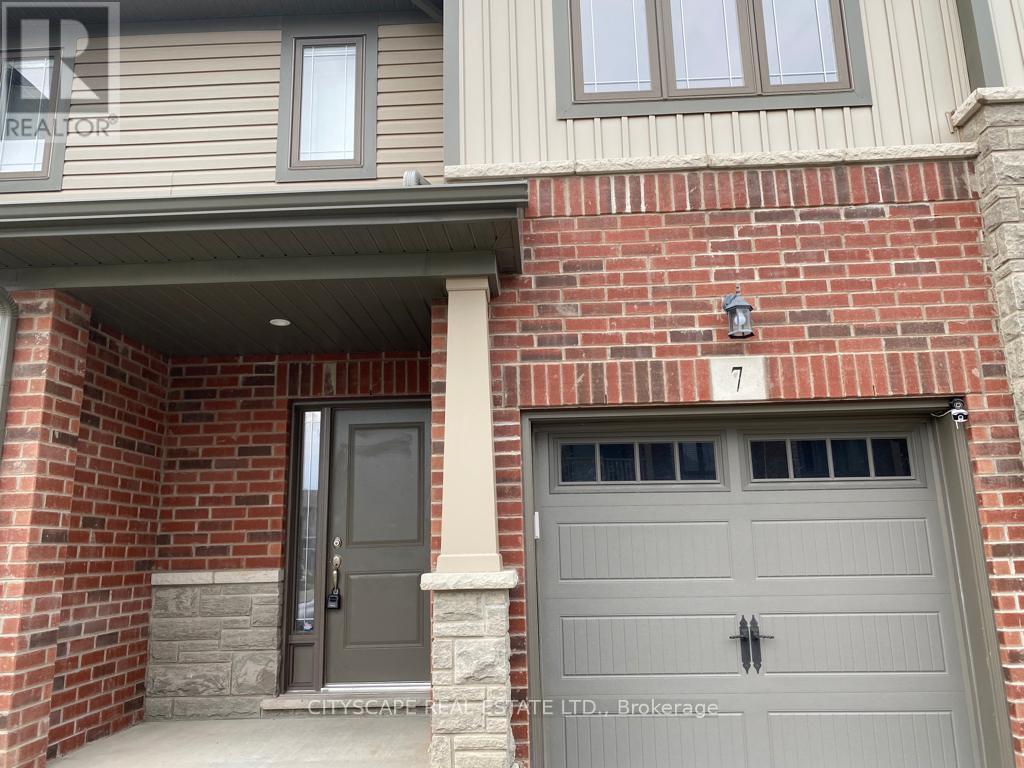 A house with a grey front door and a garage door.