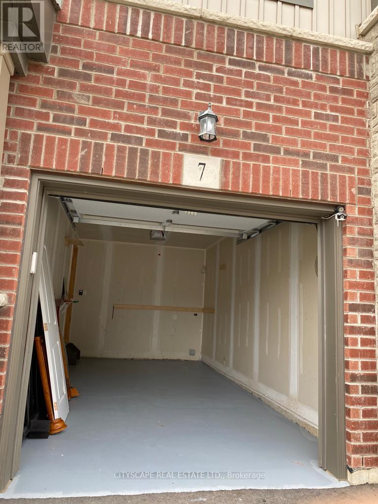 A garage door is open to reveal a spacious empty garage.