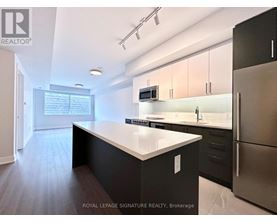 A modern kitchen with a large island and stainless steel appliances.